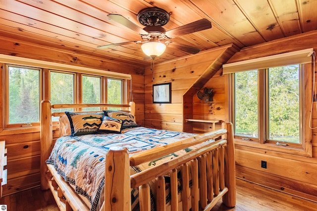 bedroom featuring wooden walls, ceiling fan, hardwood / wood-style floors, and wooden ceiling