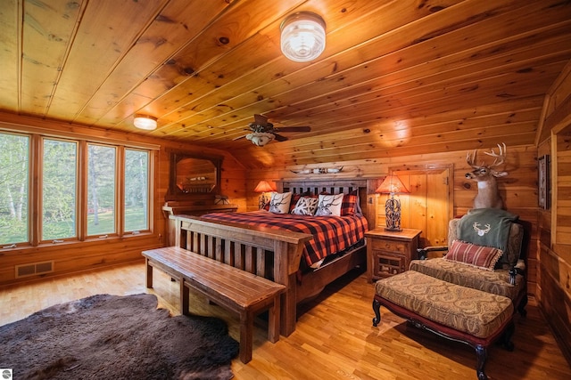 bedroom featuring wood ceiling, light hardwood / wood-style flooring, and wooden walls