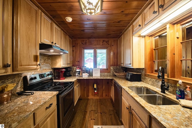 kitchen with wooden walls, stainless steel electric range, sink, light stone countertops, and dark wood-type flooring