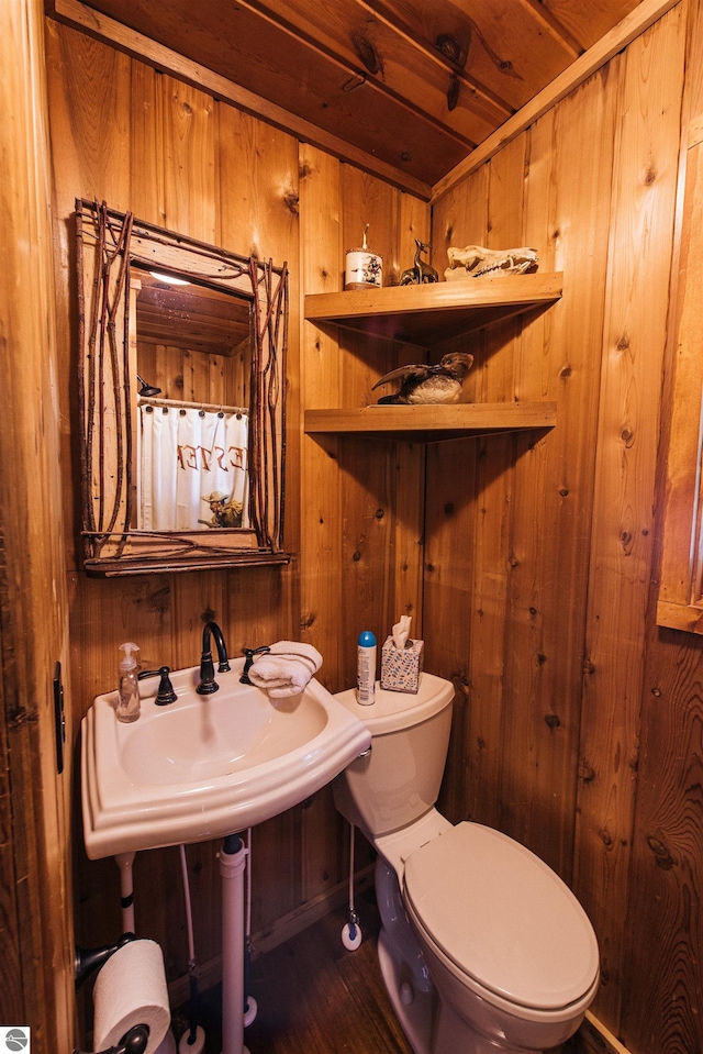 bathroom featuring toilet and wooden walls