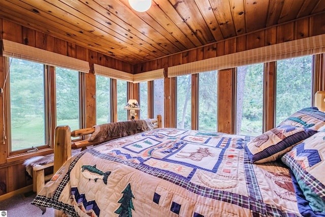 bedroom featuring wood walls, multiple windows, and wooden ceiling