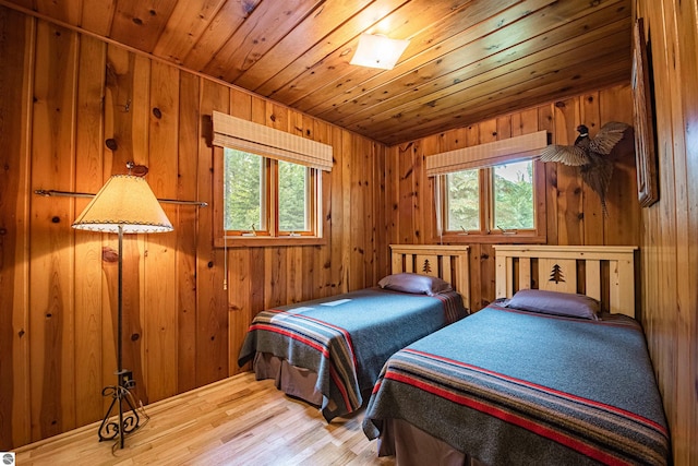 bedroom with hardwood / wood-style floors, multiple windows, wooden walls, and wooden ceiling