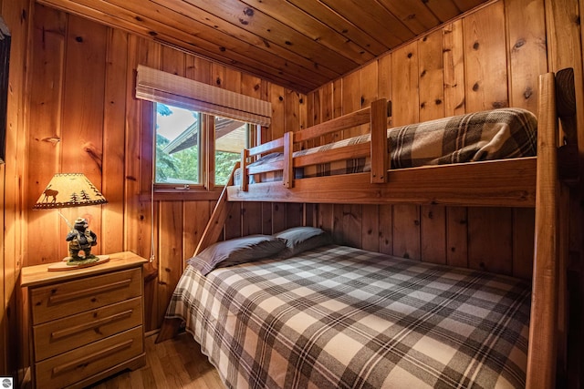 bedroom with wood walls, wood ceiling, and light wood-type flooring