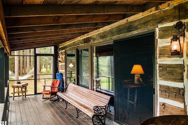 sunroom / solarium featuring a wealth of natural light, wooden ceiling, and vaulted ceiling with beams