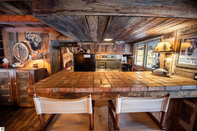 dining space featuring wood ceiling, wood walls, and dark hardwood / wood-style floors