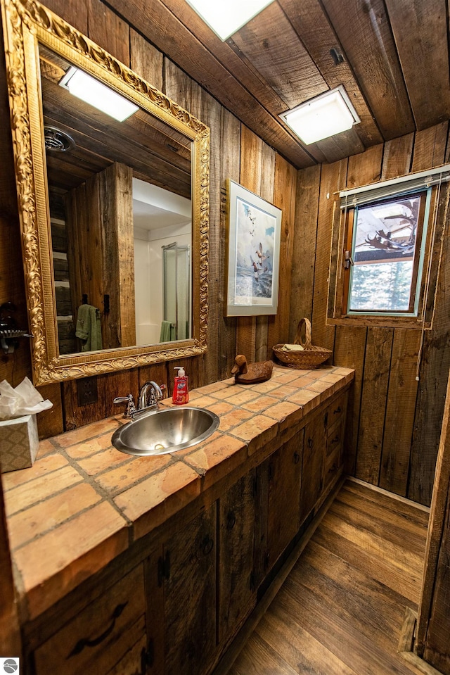 bathroom featuring wood walls, vanity, hardwood / wood-style floors, and wood ceiling