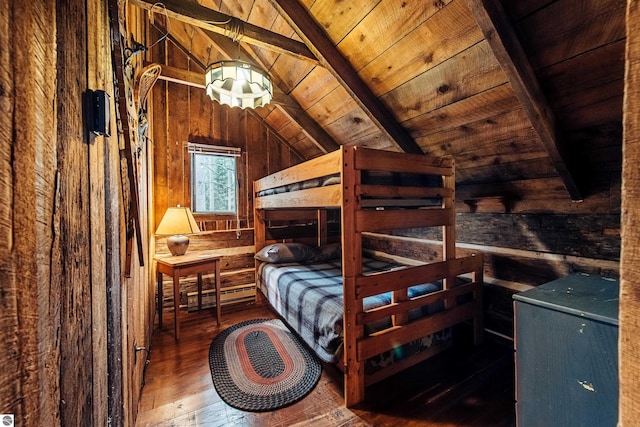 unfurnished bedroom featuring wooden walls, vaulted ceiling with beams, wooden ceiling, and hardwood / wood-style floors