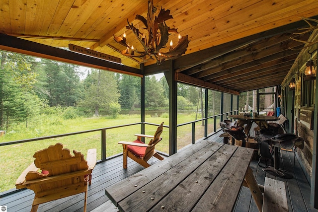 unfurnished sunroom with wood ceiling, a wealth of natural light, and vaulted ceiling with beams