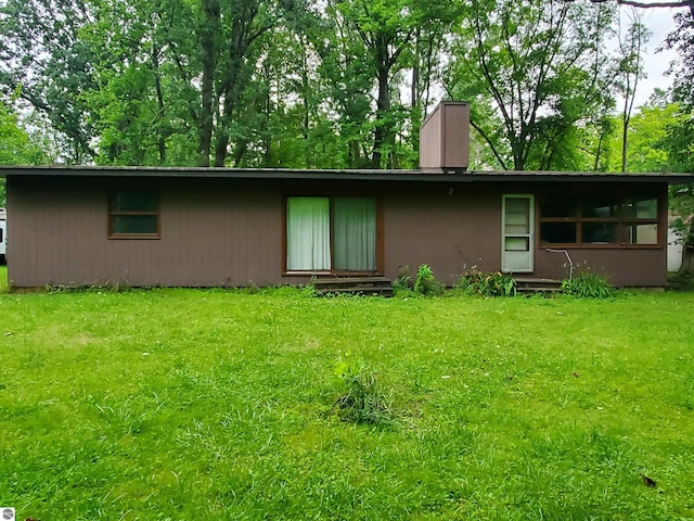 rear view of property featuring a yard