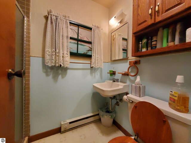 bathroom featuring a baseboard radiator, sink, an enclosed shower, and toilet