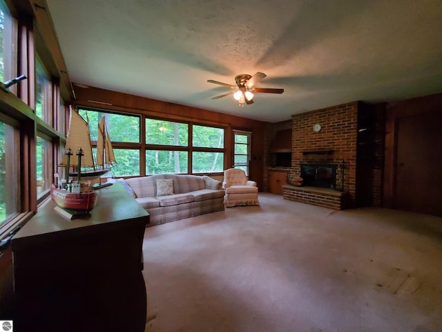 carpeted living room featuring a fireplace and ceiling fan