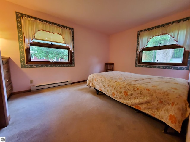 carpeted bedroom featuring multiple windows and a baseboard heating unit