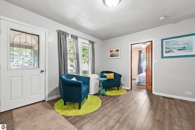 224 Saint Marys St, Suttons Bay, MI 49682 - sitting room featuring visible vents, baseboards, a textured ceiling, and wood finished floors