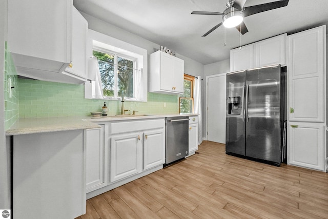 224 Saint Marys St, Suttons Bay, MI 49682 - kitchen featuring a sink, light wood-style floors, appliances with stainless steel finishes, white cabinets, and light countertops