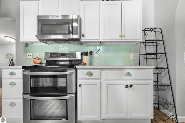 224 Saint Marys St, Suttons Bay, MI 49682 - kitchen with white cabinetry, light countertops, tasteful backsplash, and stainless steel appliances