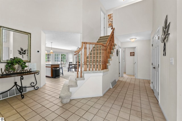 hallway featuring a high ceiling and light tile patterned floors