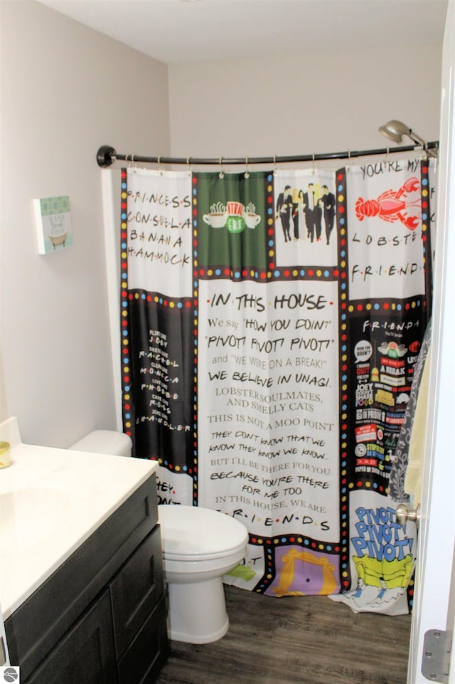 bathroom with vanity, curtained shower, toilet, and wood finished floors