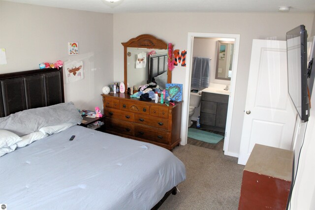 carpeted bedroom with sink and connected bathroom