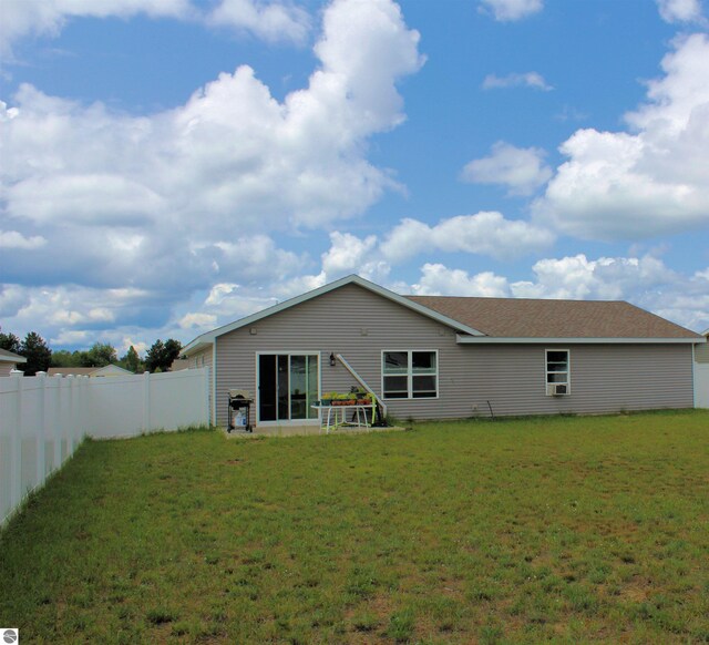 rear view of property featuring a lawn