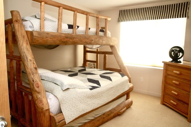 bedroom featuring light carpet and baseboards