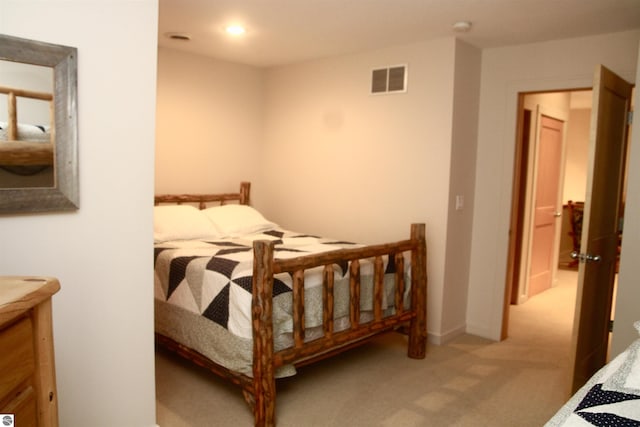 bedroom featuring visible vents and light colored carpet