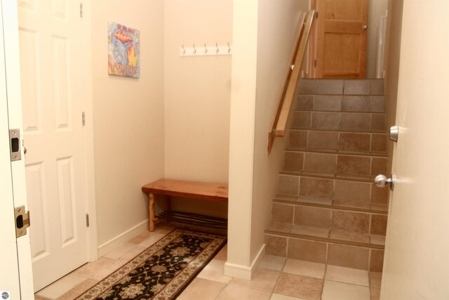 washroom featuring light tile patterned floors and stacked washer / dryer