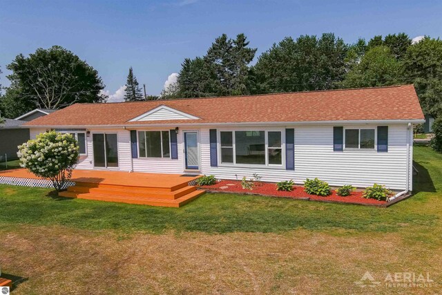 ranch-style house featuring a deck and a front lawn