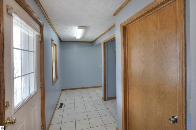 hallway featuring crown molding, a textured ceiling, and light tile patterned floors