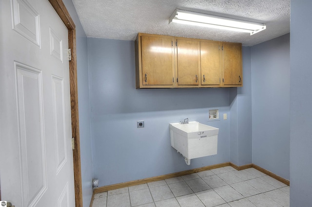 washroom with sink, cabinets, hookup for a washing machine, electric dryer hookup, and a textured ceiling