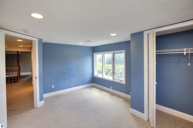 unfurnished bedroom featuring carpet flooring, a textured ceiling, and a closet