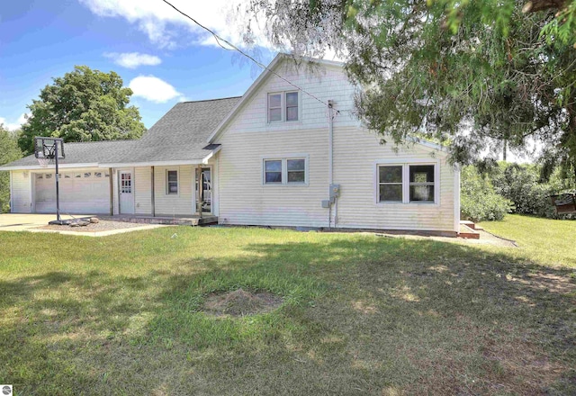 back of property featuring a garage and a yard