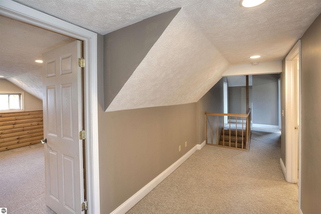 bonus room featuring vaulted ceiling, light colored carpet, and a textured ceiling