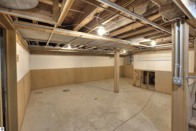 basement featuring wood walls