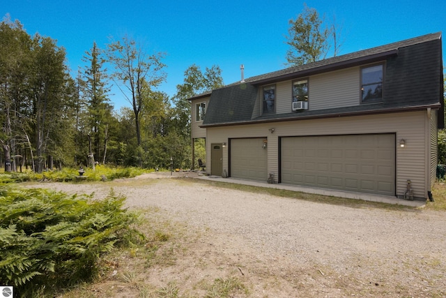 view of front of house with a garage and cooling unit