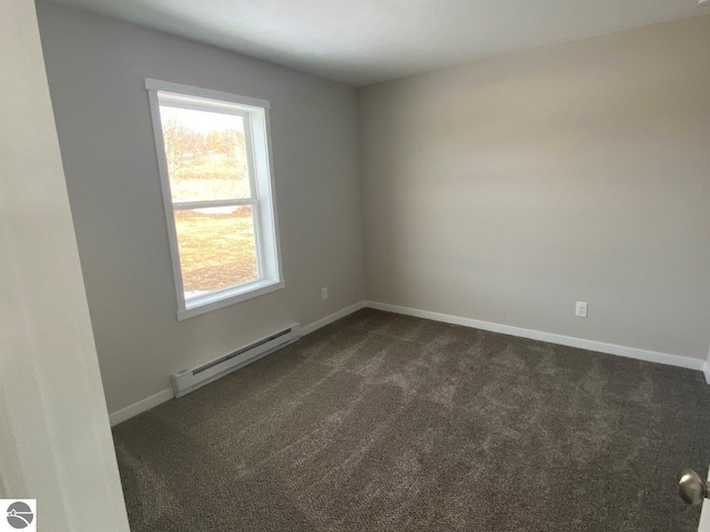 unfurnished room with baseboard heating and dark carpet