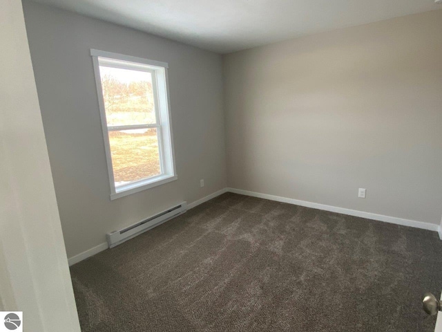 empty room featuring dark carpet, baseboards, and baseboard heating