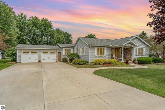 single story home featuring a garage and a yard