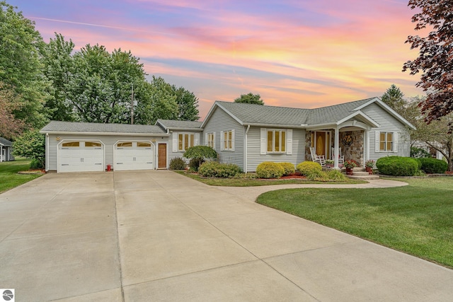 single story home featuring a garage and a lawn