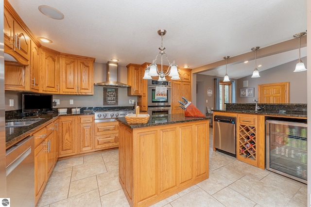 kitchen with pendant lighting, stainless steel appliances, a center island, wine cooler, and wall chimney exhaust hood