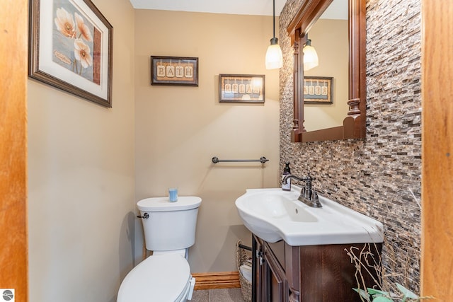 bathroom with vanity, tasteful backsplash, and toilet