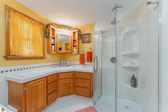 bathroom with vanity, a shower with shower door, and tile patterned flooring