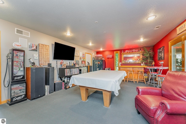 rec room with billiards, carpet, a textured ceiling, and bar area