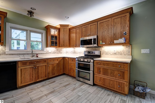 kitchen featuring tasteful backsplash, stainless steel appliances, sink, and light wood-type flooring