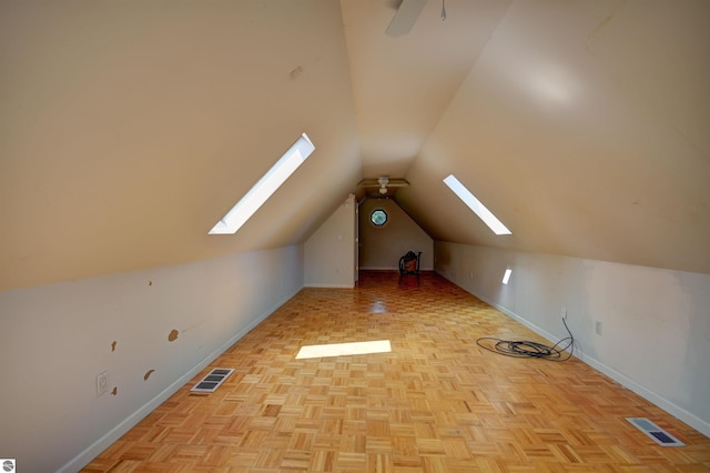 bonus room featuring ceiling fan, vaulted ceiling with skylight, and light parquet floors