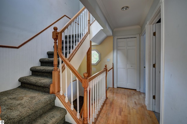 stairway featuring hardwood / wood-style floors and ornamental molding