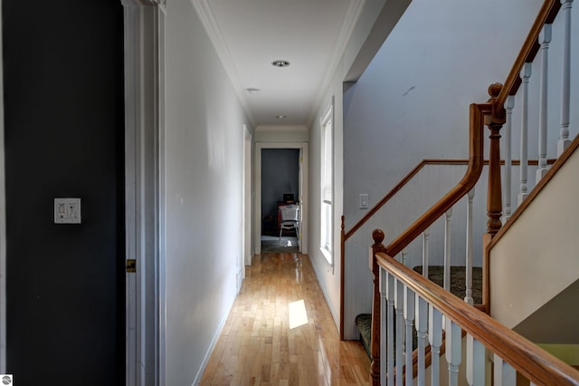 hall with ornamental molding and light hardwood / wood-style flooring