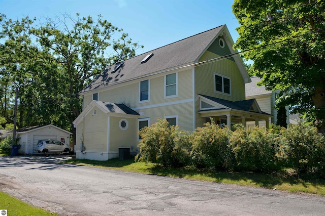 view of front facade featuring a garage, an outdoor structure, and central air condition unit