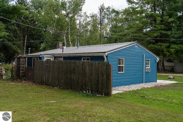 view of side of home featuring cooling unit and a lawn