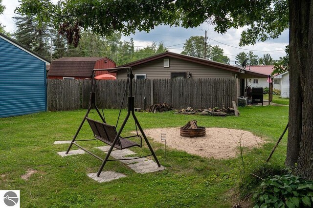 view of jungle gym with a fire pit and a lawn