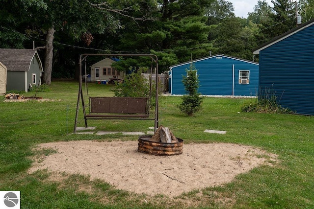 view of yard featuring an outdoor structure and a fire pit